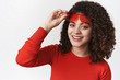 © Cookie Studio - Curly-haired stylish charming girl take off red sunglasses look you meet friend sunny walk park standing white background smiling delighted enjoy cool holidays, look happy carefree
