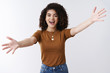 © Cookie Studio - Excited happy attractive stylish modern girl welcoming best friend spread arms sideways cuddle wanna hug say hi happily delighted see sibling hugging waiting tender warm embraces, white background