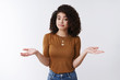 © Cookie Studio - Not big deal. Unbothered careless stylish young modern female curly dark hair shrugging hands spread sideways smirking unaware look confused clueless, cannot help no idea shrugging, white background