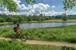 © Uwe - nice senior woman, riding her electric mountain bike along the Weiherwiesen Lake, a biotope on the Swabian Alb near Heubach, Baden-Wuerttemberg, Germany