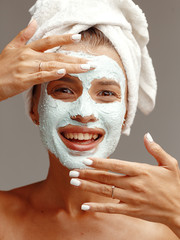 Portrait of a young attractive girl with a cosmetic mask on her face. Close-up. Face skin care concept.