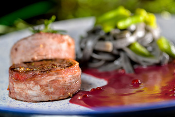 two steaks of minignon on a plate in a sauce