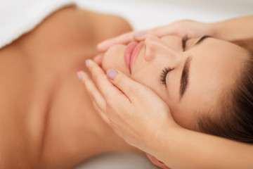 woman getting face massage at beauty salon, closeup