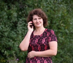 Wall Mural - Woman in nature talking on a cell phone