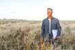 © Freepik - Smiley man standing in a wheat field