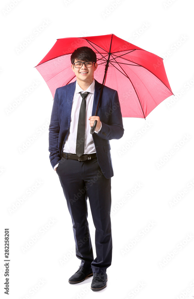 Handsome Asian businessman with umbrella on white background