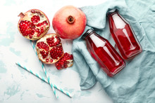Composition With Bottles Of Fresh Pomegranate Juice On Light Background