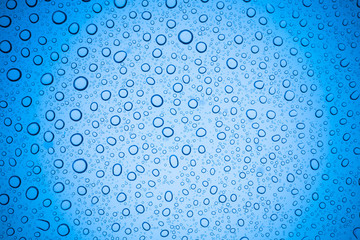 Rain droplets on blue glass background, Water drops on glass.