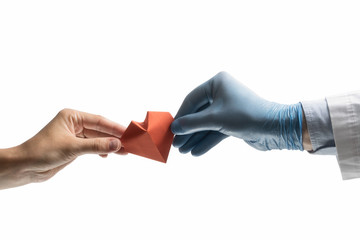 Doctor's hand gives a red paper heart to a woman. Image on isolated white background. Concept of salvation, donorship, helping hand.