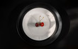 Above view to the two fresh sweet red cherries on a white porcelain dish and a black plate, a black background, a restaurant concept.healthy food concept.