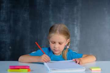 Schoolgirl does homework at school desk