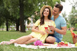 © New Africa - Happy young couple having picnic in park on summer day