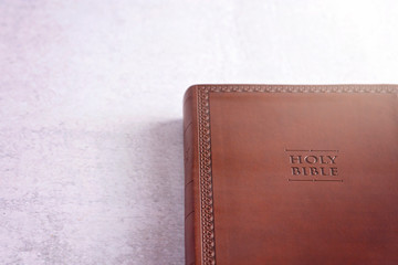 Poster - A Brown Leather Holy Bible on a White and Gray Concrete Surface