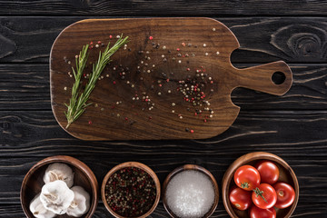 Wall Mural - top view of cutting board, cherry tomatoes, greenery, salt, garlics and spices