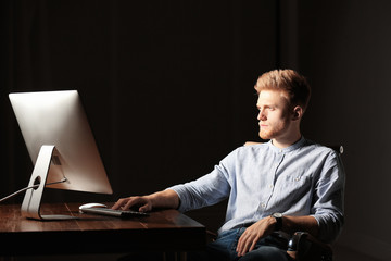 Poster - Concentrated young man working in office alone at night