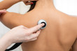 © Kate - Woman doctor therapist listening with a stethoscope to a back, young female patient