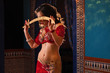 Oriental professional belly dancer in carnival shining costume with long healthy glossy hair and cane. Exotic star of bellydance. Belly Dancer During Show. Sword dance