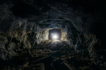Canvas Print - Dark dirty abandoned uranium mine with rusty remnants of railway