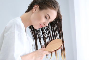 Canvas Print - Beautiful young woman brushing hair after washing at home