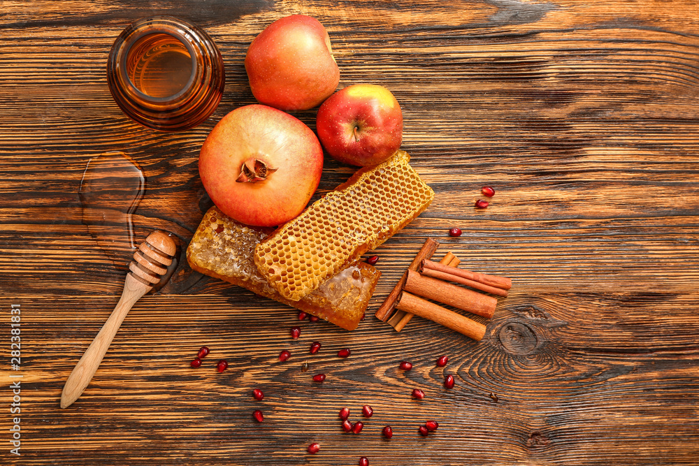 Composition with sweet honey, apples and pomegranate on wooden background