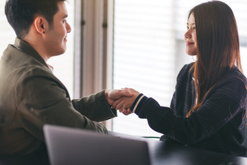 Poster - Closeup image of two businesspeople shaking hands in a meeting