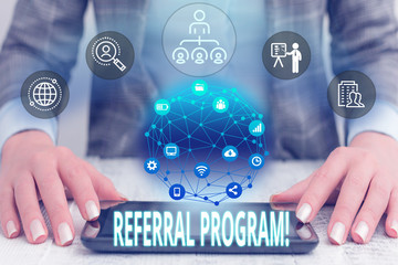 Conceptual hand writing showing Referral Program. Concept meaning internal recruitment method employed by organizations Female human wear formal work suit presenting smart device