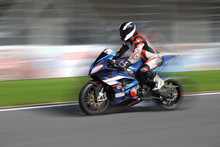 Motorcycle Rider Racing On Race Track With Motion Blur