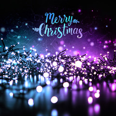 Wall Mural - Sparkling Christmas lights in the evening at night on a dark background and the inscription Merry Christmas. Blue and purple color.