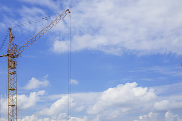 Copy space near construction crane against blue cloudy sky