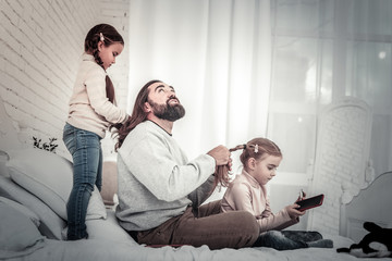 Kids and father playing wih each other hair