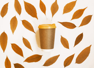 Morning coffee cup concept. Coffee to go with autumn leaves background.