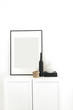 © Floral Deco - Photo frame on chest of drawers with decoration at white wall. Minimal modern Scandinavian interior design concept.