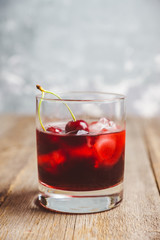 Wall Mural - Old fashioned cherry cocktail with berries. Selective focus. Shallow depth of field. 