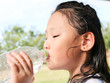 © nuiiko - Asian girl drinking a bottle of water outdoor.