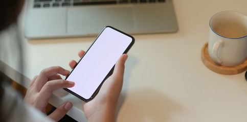 Cropped view of teenage girl holding blank screen smartphone