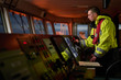 © Denys Yelmanov  - Navigator. pilot, captain as pat of ship crew performing daily duties with VHF radio, binoculars on board of modern ship with high quality navigation equipment on the bridge on sunrise.