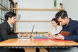 © DragonImages - Group of business people sitting at the table working with documents and laptop computer during work day at office
