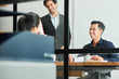 © DragonImages - Group of young successful business people smiling and talking to each other during business meeting at office