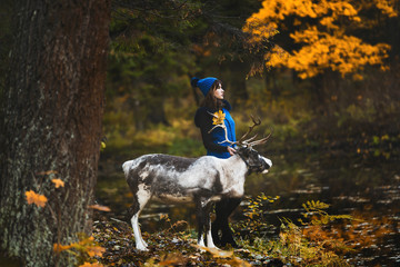 a beautiful girl model walking with deer in the park