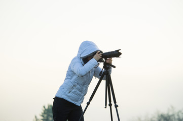 photographer with camera and tripod outdoor taking landscape picture