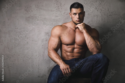 Cuadros en Lienzo Massive bodybuilder posing beside the concrete wall