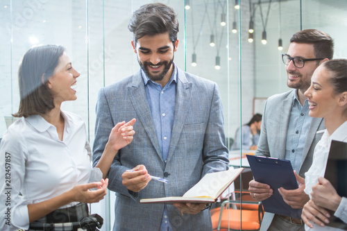 Cuadros en Lienzo Business team discussing business documents, standing in the office lobby
