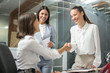 © Bojan - Business women shaking hands in meeting room