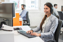 Friendly Customer Support Service Operator With Headset Working In Call Centre.