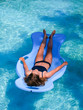 © KARL70 - Beautiful athletic sun tanned girl floating on a pool float in a swimming pool on vacation