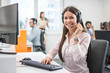 © Bojan - Positive female customer services agent with headset working in call center