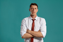 Young Man In A Classic White Shirt And Red Tie Posing Over A Blue Background.