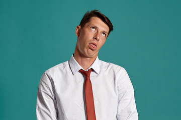 Young man in a classic white shirt and red tie posing over a blue background.