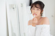 © NT_studio - Beautiful portrait young asian woman looking mirror applying makeup lipstick at room, beauty lips asia girl makeup and cosmetic fashion on mouth at home, lifestyle and health care concept.