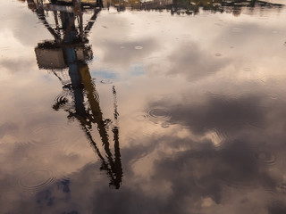 Reflection of the gantry crane in the water on a cloudy day with light rain.